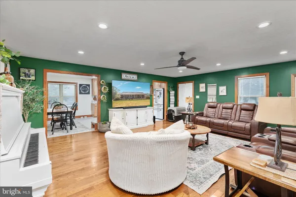 a kitchen with stainless steel appliances granite countertop a stove a sink dishwasher and white cabinets with wooden floor