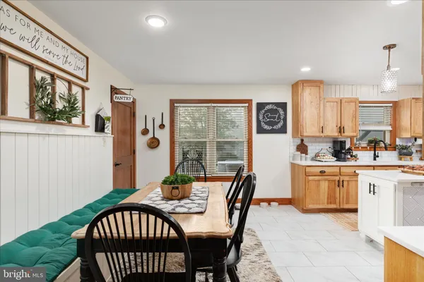 a kitchen that has a refrigerator a stove a dining table and chairs with wooden floor