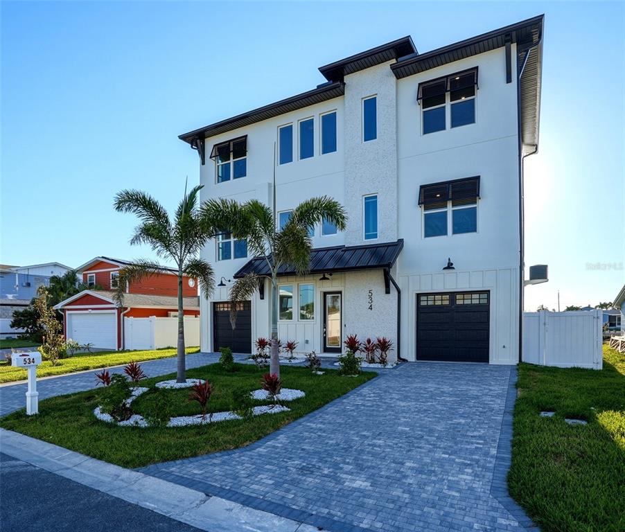 534 Crystal Drive Madeira Beach, FL 33708 - Photo 62 of 68 a front view of a house with a yard and garage