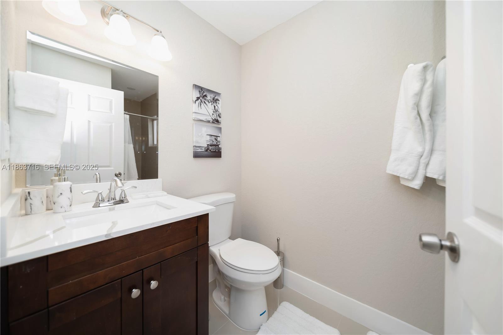1183 Northeast 111th Street, Unit 1183 Miami, FL 33161 - Photo 16 of 20 a bathroom with a sink vanity mirror and toilet