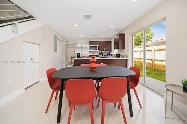 a dining room with furniture and a floor to ceiling window