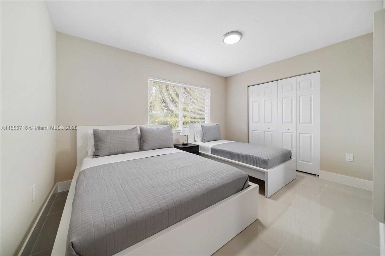 1183 Northeast 111th Street, Unit 1183 Miami, FL 33161 - Photo 9 of 20 a bedroom with two beds and a window