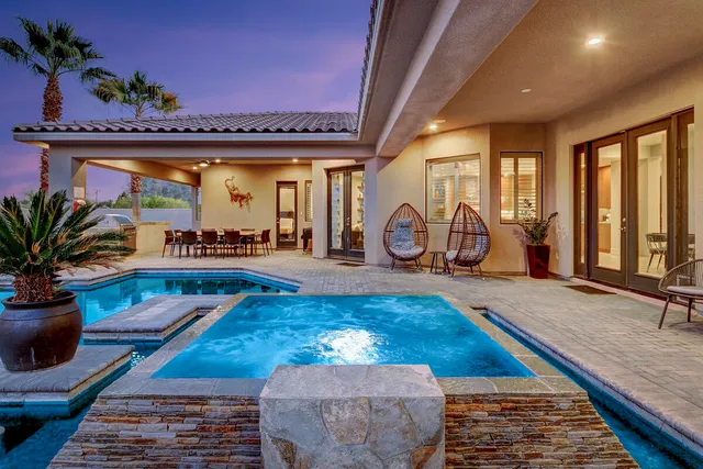 a bed sitting in a spacious bedroom next to a larger window