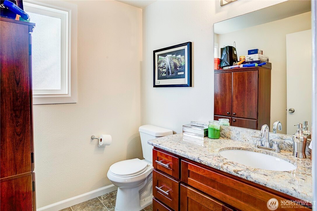 2357 Northwest 65th Street Seattle, WA 98117 - Photo 11 of 20 a bathroom with a granite countertop toilet sink and mirror