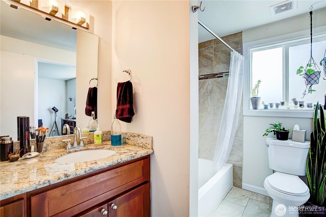2357 Northwest 65th Street Seattle, WA 98117 - Photo 12 of 20 a bathroom with a granite countertop sink toilet and shower