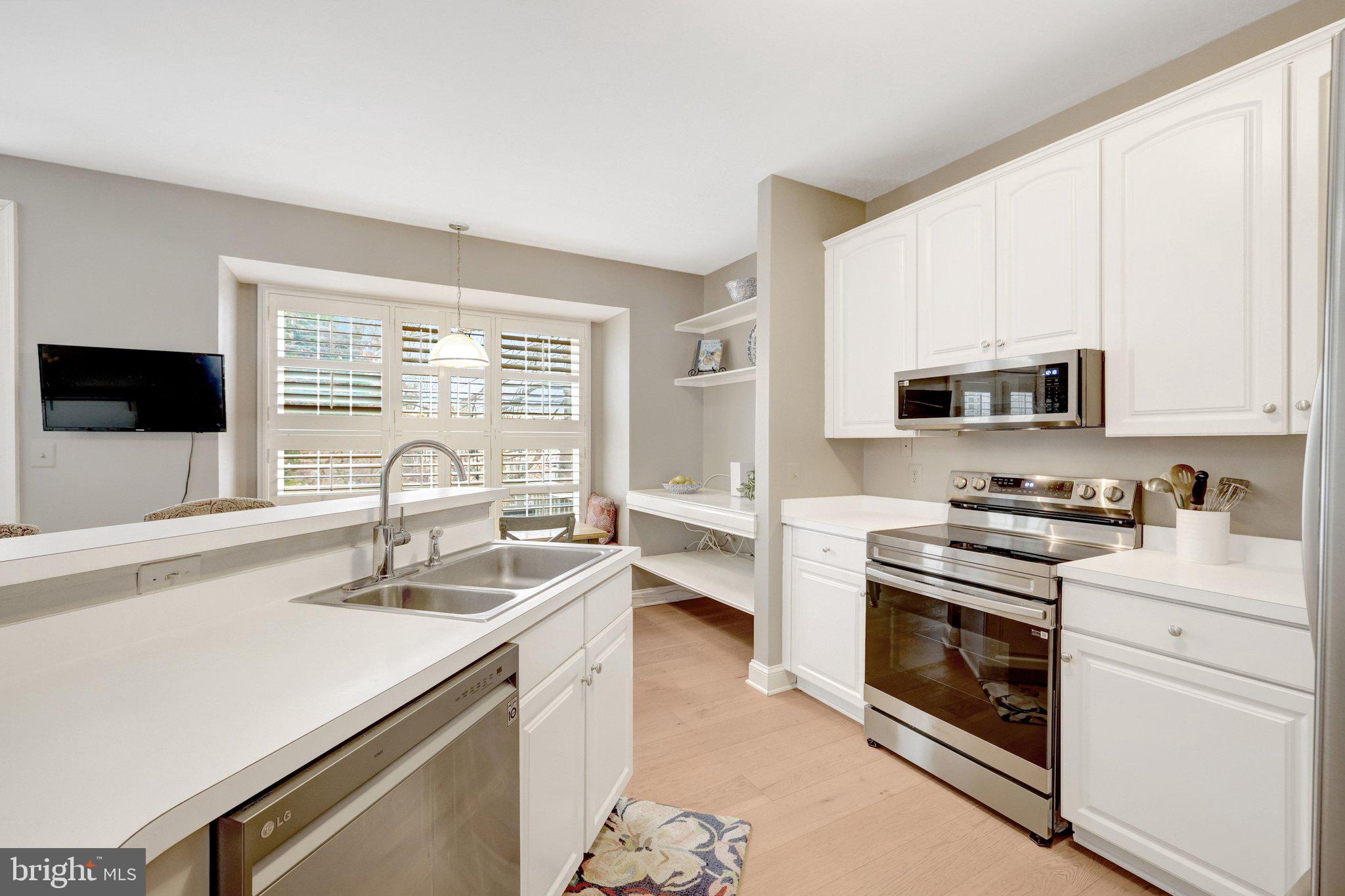 1309 Sundial Drive Reston, VA 20194 - Photo 5 of 45 a kitchen with stainless steel appliances granite countertop a sink a stove a microwave and wooden cabinets