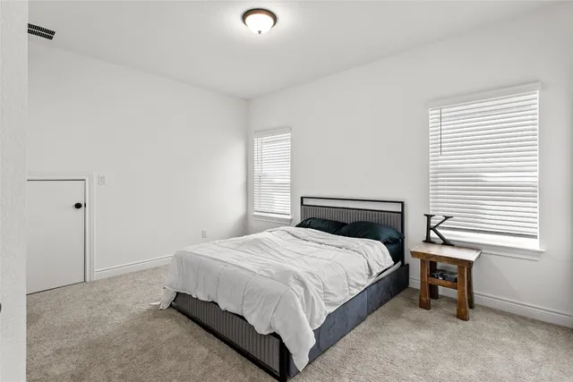 a bedroom with a bed table and a window