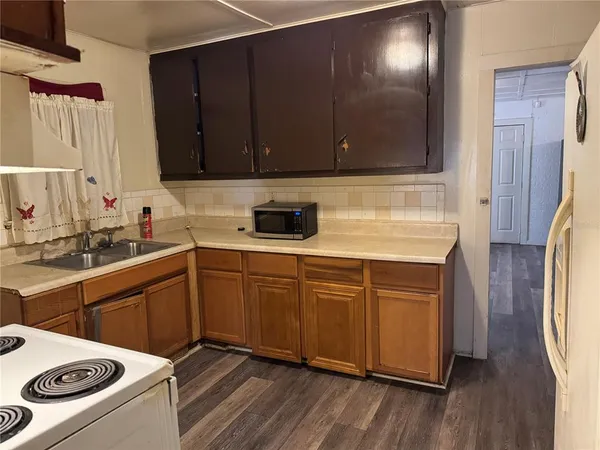 a kitchen with a sink a stove and cabinets
