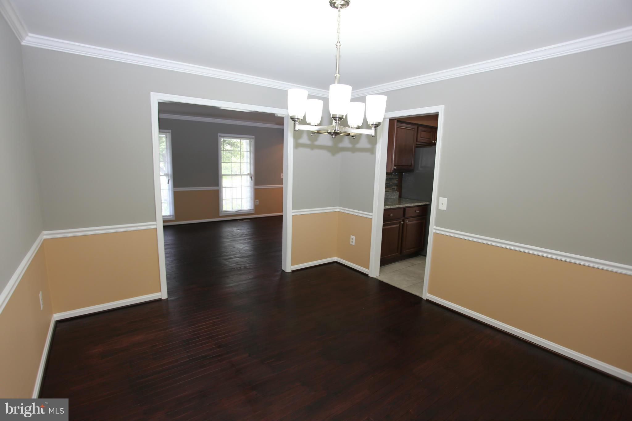 703 Monarch Ridge Road Frederick, MD 21703 - Photo 7 of 30 a view of a livingroom with wooden floor and a chandelier