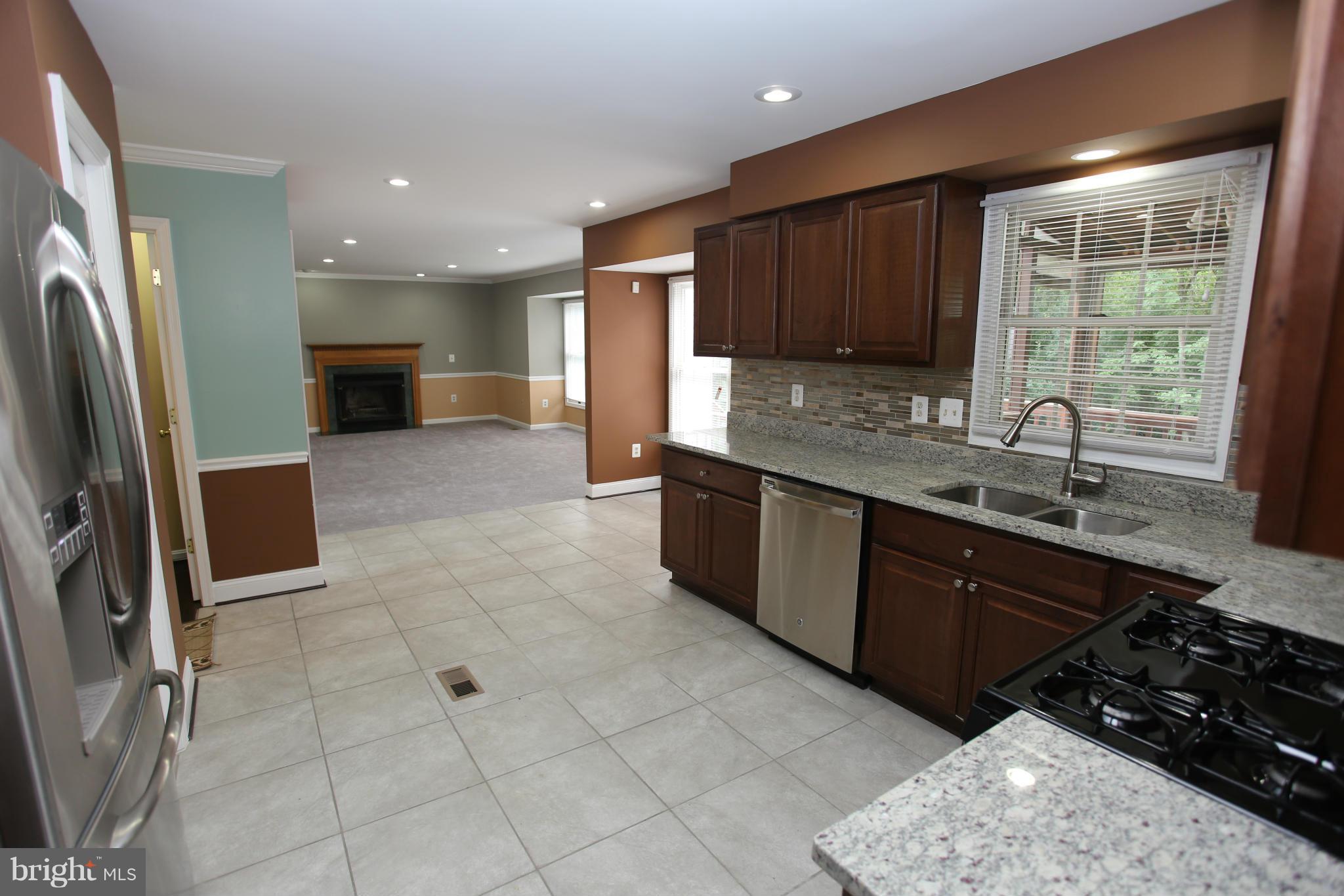 703 Monarch Ridge Road Frederick, MD 21703 - Photo 8 of 30 a large kitchen with stainless steel appliances granite countertop a sink stove and cabinets