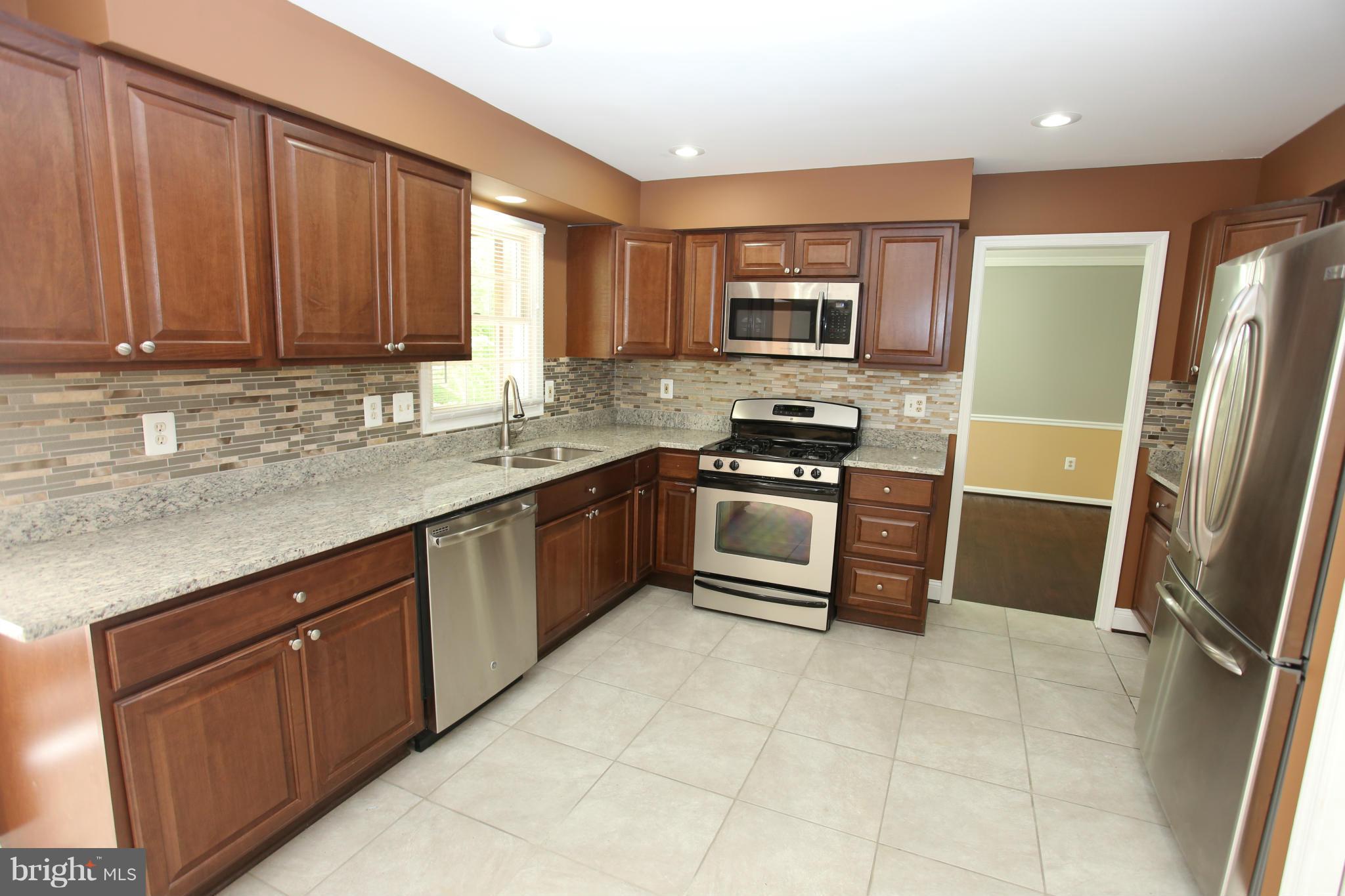 703 Monarch Ridge Road Frederick, MD 21703 - Photo 9 of 30 a kitchen with stainless steel appliances granite countertop a stove a sink and a refrigerator