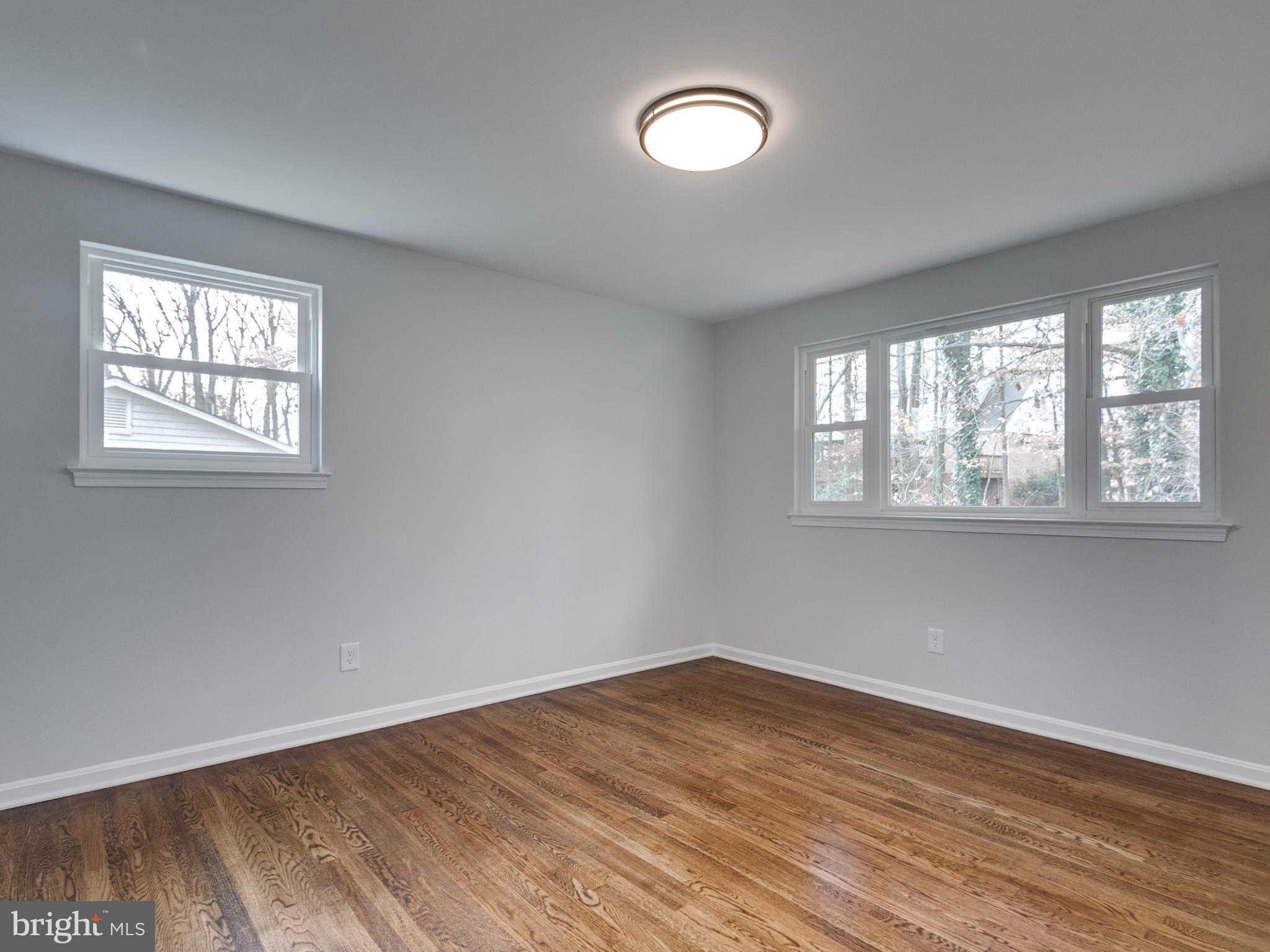 8918 Victoria Road Springfield, VA 22151 - Photo 14 of 30 an empty room with wooden floor and windows