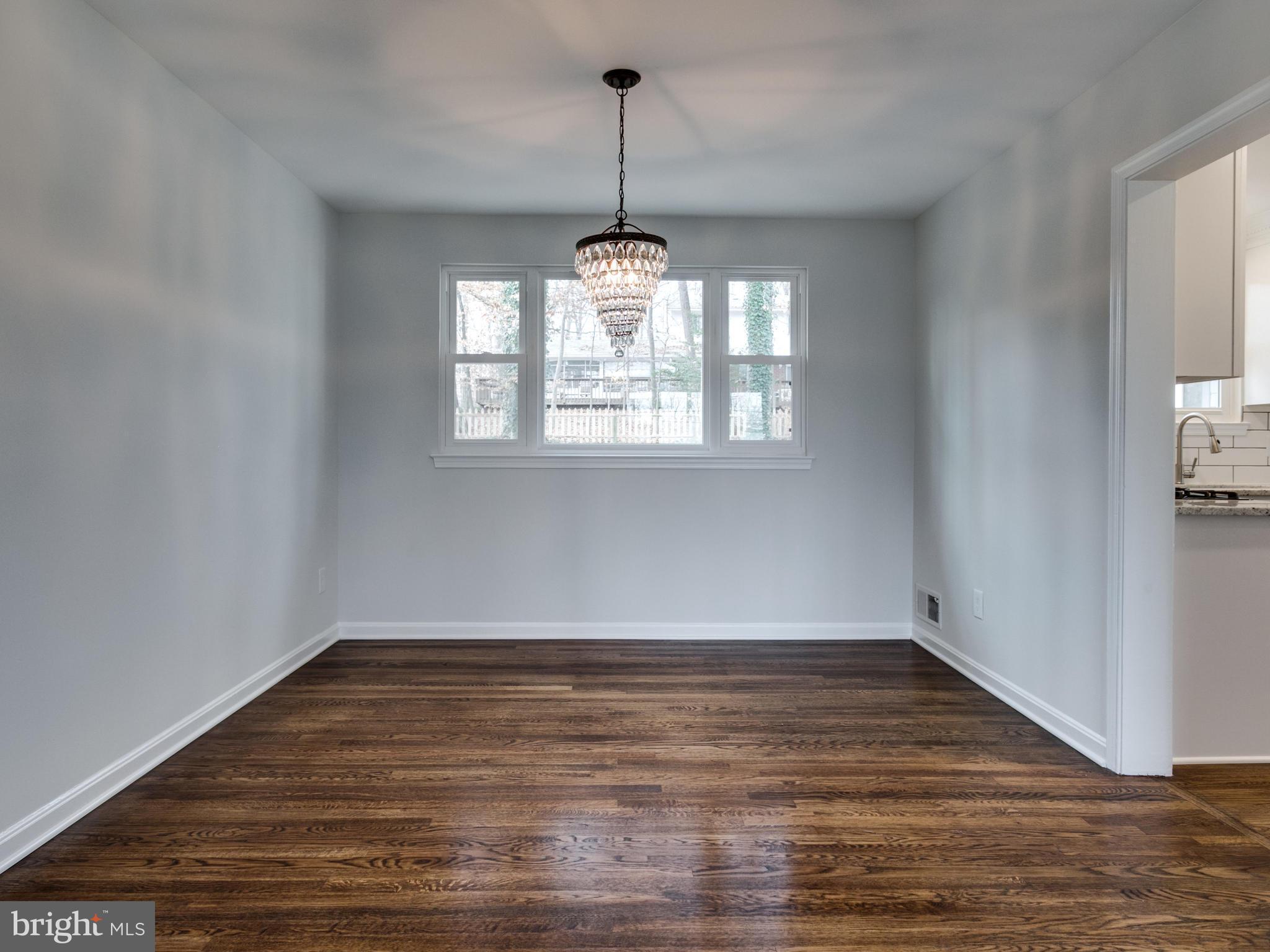 8918 Victoria Road Springfield, VA 22151 - Photo 4 of 30 a view of an empty room with wooden floor and a window