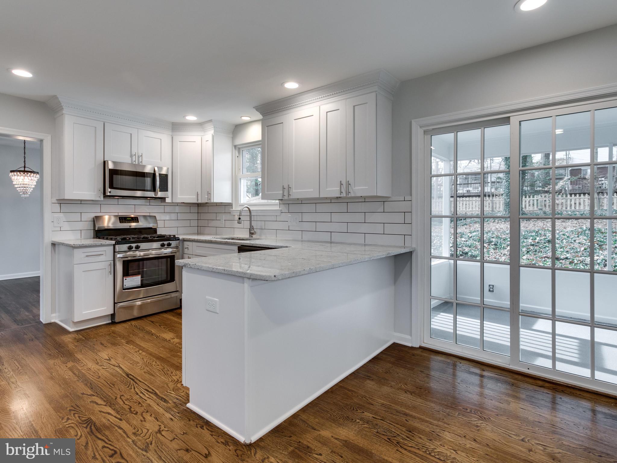 8918 Victoria Road Springfield, VA 22151 - Photo 7 of 30 a kitchen with stainless steel appliances granite countertop a stove a sink and a microwave