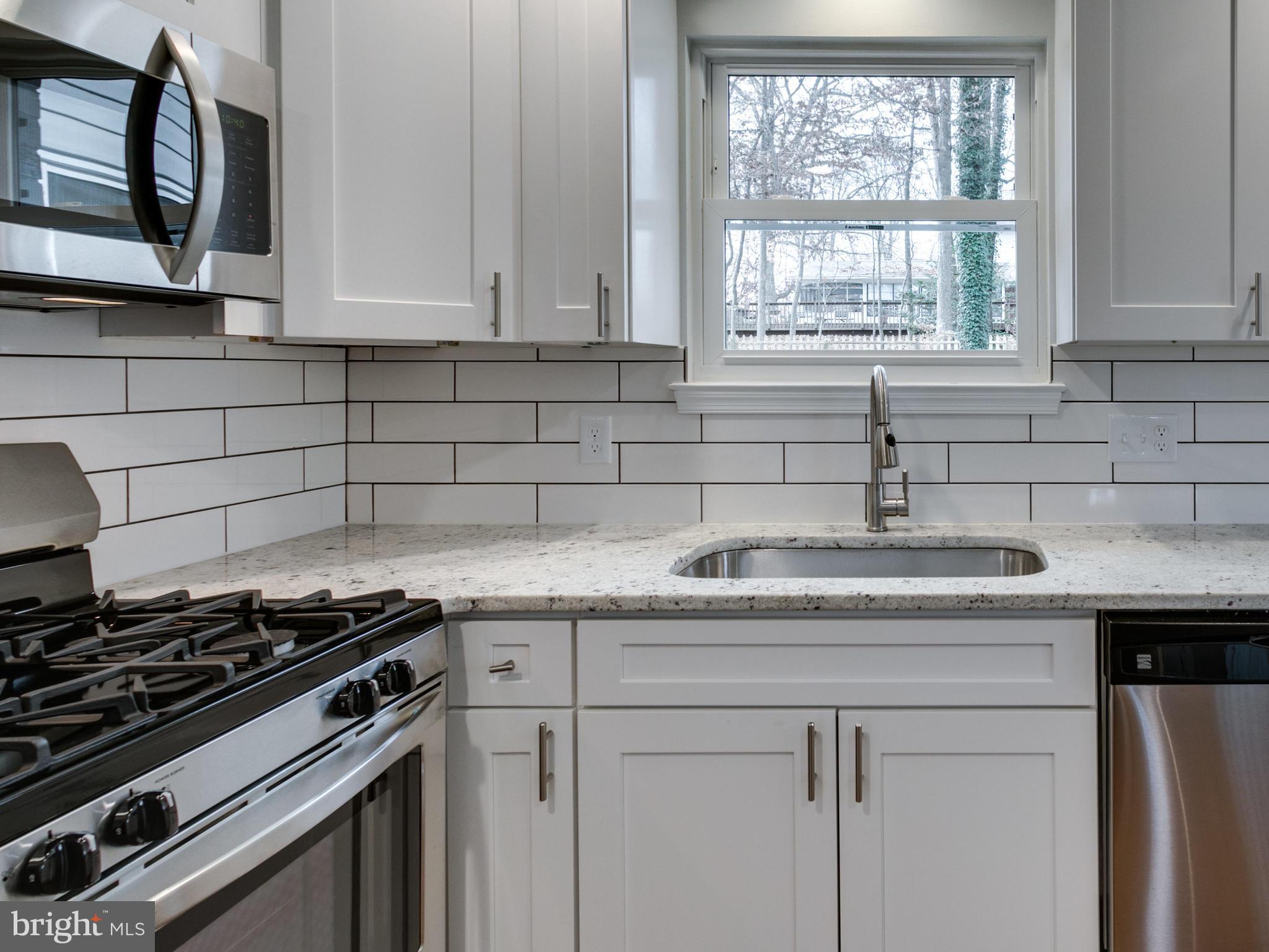 8918 Victoria Road Springfield, VA 22151 - Photo 8 of 30 a kitchen with granite countertop a sink stainless steel appliances window and cabinets