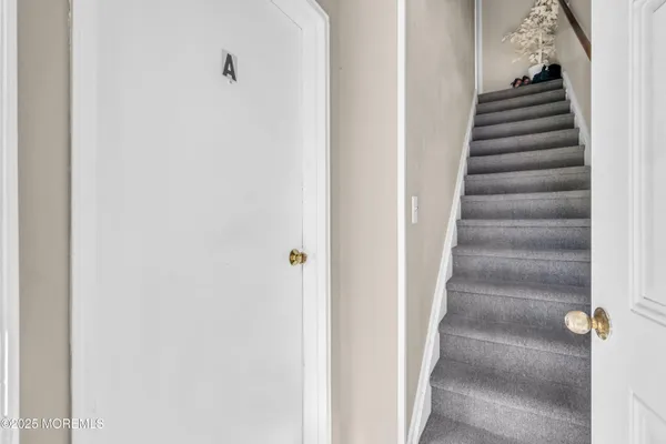 a view of an empty room with wooden floor and closet