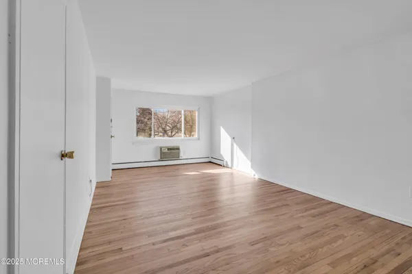 a view of a room with wooden floor and window