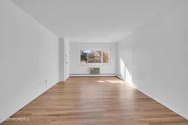a view of a room with wooden floor and window