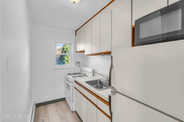 a kitchen with a sink a refrigerator and cabinets
