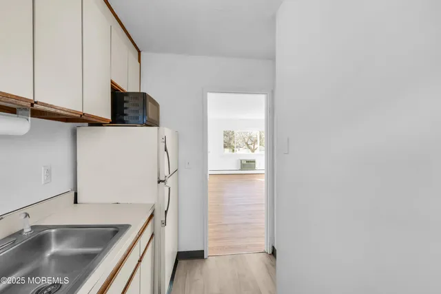 a kitchen with a sink a refrigerator and cabinets