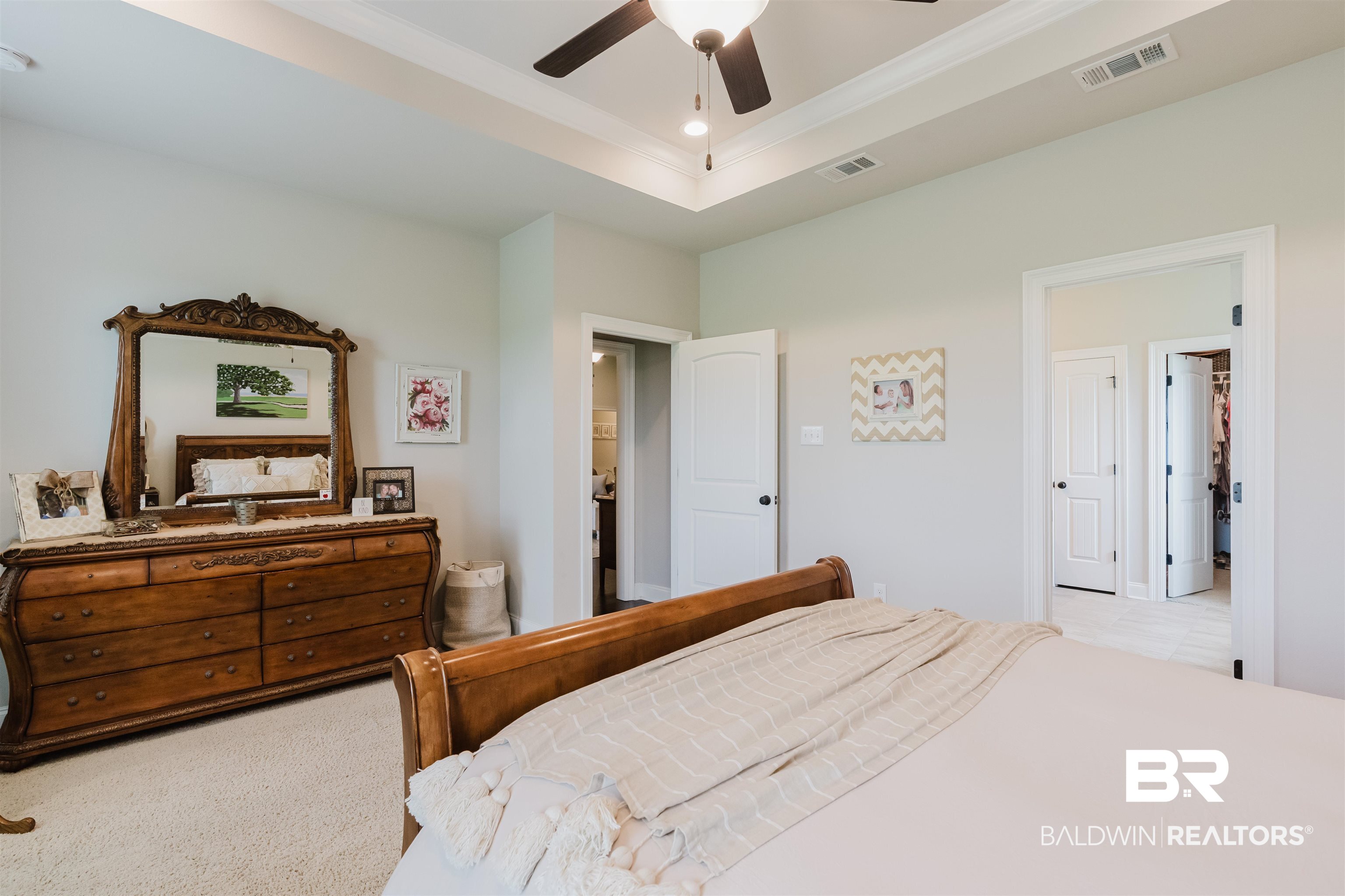 12128 Red Barn Road Fairhope, AL 36532 - Photo 25 of 47 Bedroom featuring ceiling fan, crown molding, and a raised ceiling