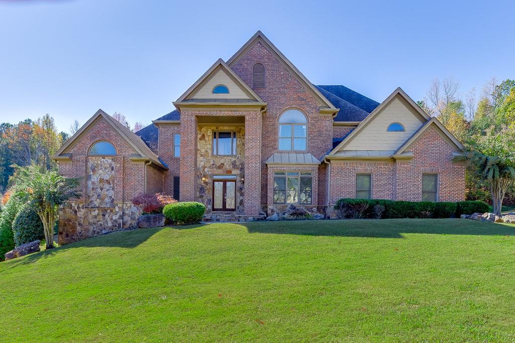 940 Chateau Forest Road Hoschton, GA 30548 - Photo 3 of 87 a front view of a house with a yard
