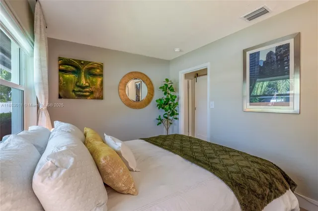 a bedroom with a bed and painting on the wall