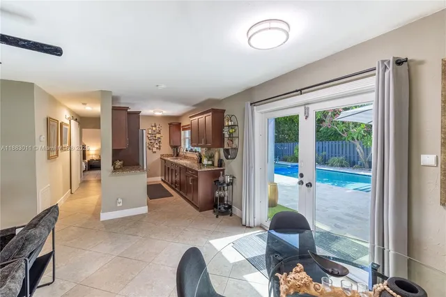 a living room with furniture a large window and stainless steel appliances