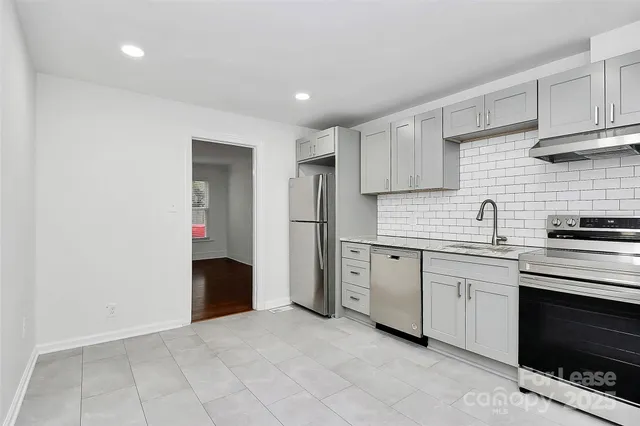 a kitchen with stainless steel appliances granite countertop a refrigerator and a stove top oven