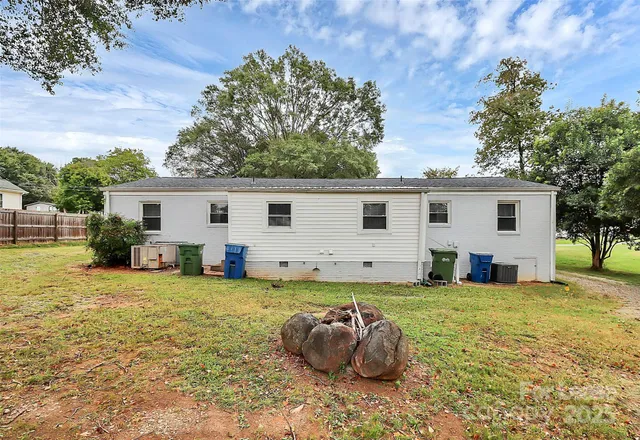 a view of a house with a backyard and a tree