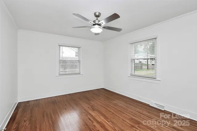 a view of a room with wooden floor and fan