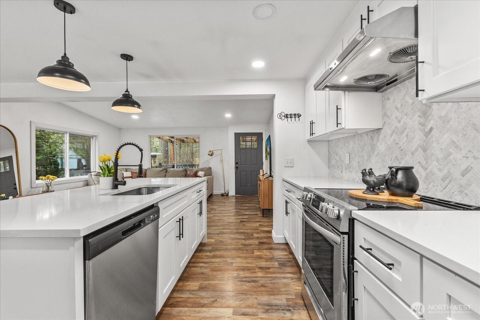 20609 Southeast 245th Place Maple Valley, WA 98038 - Photo 14 of 34 a kitchen with stainless steel appliances granite countertop a sink a stove and a wooden floors