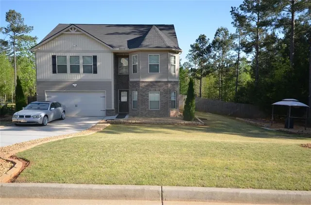 a view of a house with pool plants and large trees