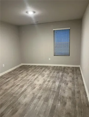 a view of an empty room with closet and a window