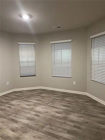 an empty room with wooden floor and closet
