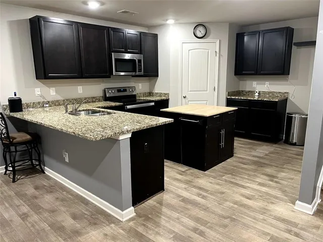 a kitchen with stainless steel appliances granite countertop a stove a sink and a microwave