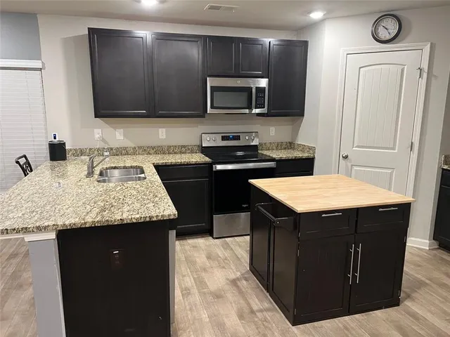 a kitchen with a stove sink and microwave