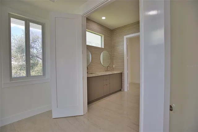 a view of an empty room with closet and a window