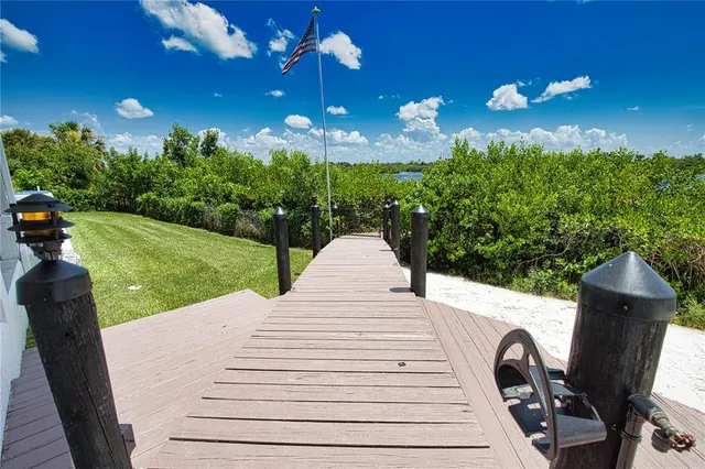a view of a patio with table and chairs a barbeque with potted plants and big trees