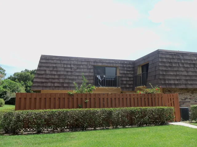 a view of a backyard with plants and wooden fence