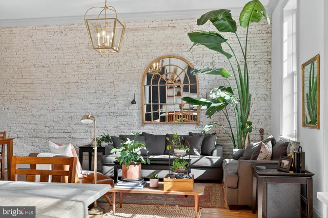 a living room with furniture chandelier and a fireplace
