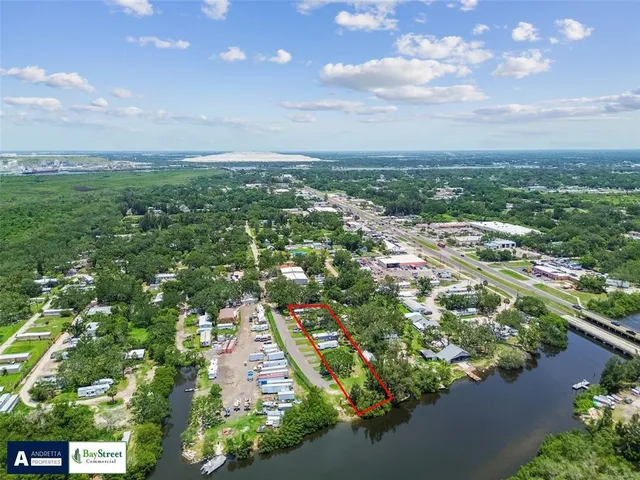 an aerial view of residential houses with outdoor space and trees