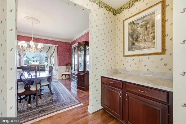 a living room with stainless steel appliances granite countertop furniture wooden floor and a large window