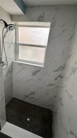 a bathroom with a sink a window and a shower