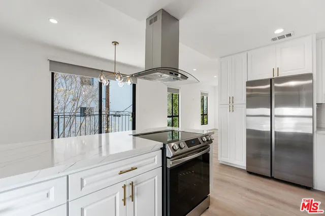 a kitchen with stainless steel appliances granite countertop a refrigerator and a stove