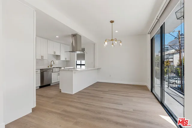 a open kitchen with white cabinets and wooden floor