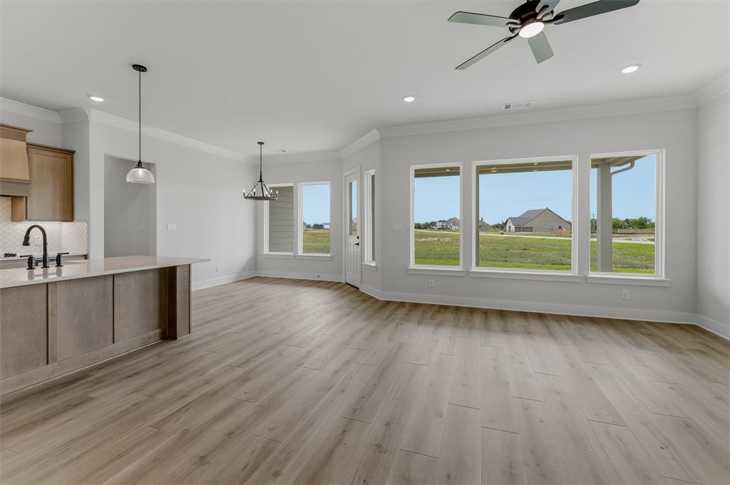 2204 Continent Court Krum, TX 76249 - Photo 15 of 28 Spacious room featuring wood-finish flooring, a contemporary ceiling fan, and multiple large windows