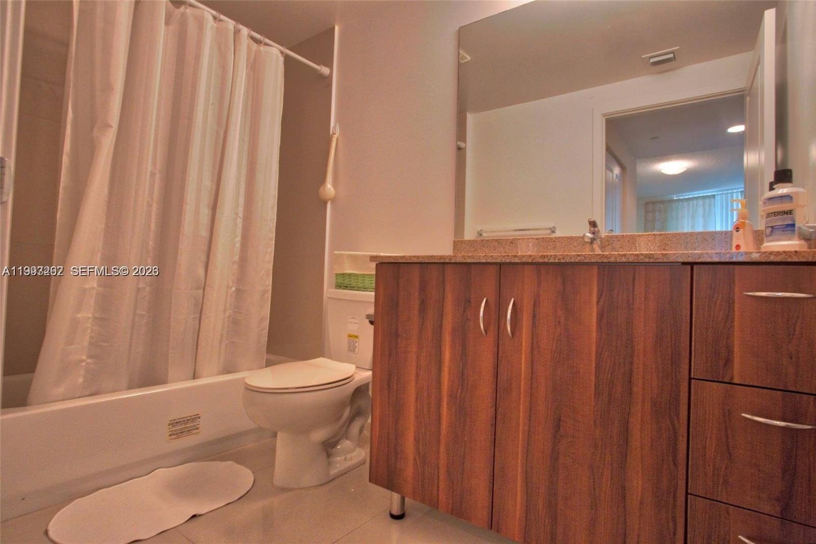 601 Northeast 23rd Street, Unit 1004 Miami, FL 33137 - Photo 11 of 17 a bathroom with a sink a toilet and shower curtain