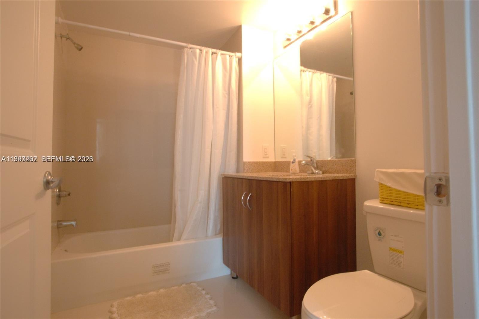 601 Northeast 23rd Street, Unit 1004 Miami, FL 33137 - Photo 12 of 17 a bathroom with a granite countertop sink toilet and shower