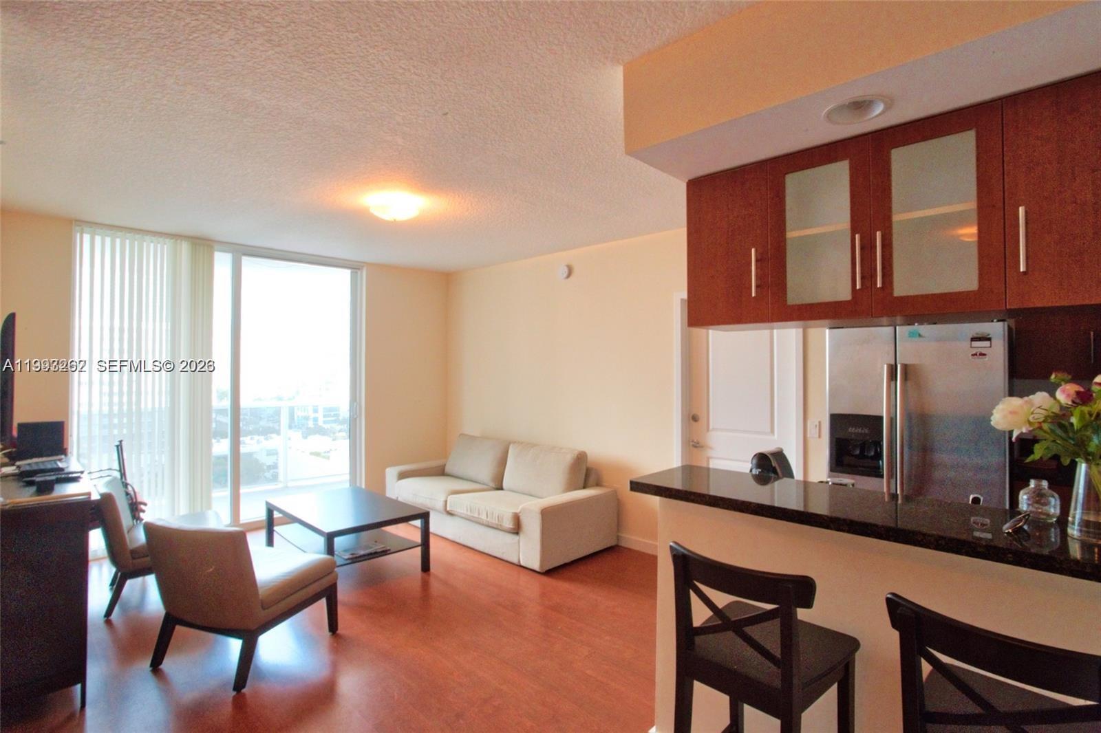 601 Northeast 23rd Street, Unit 1004 Miami, FL 33137 - Photo 2 of 17 a living room with furniture and large windows